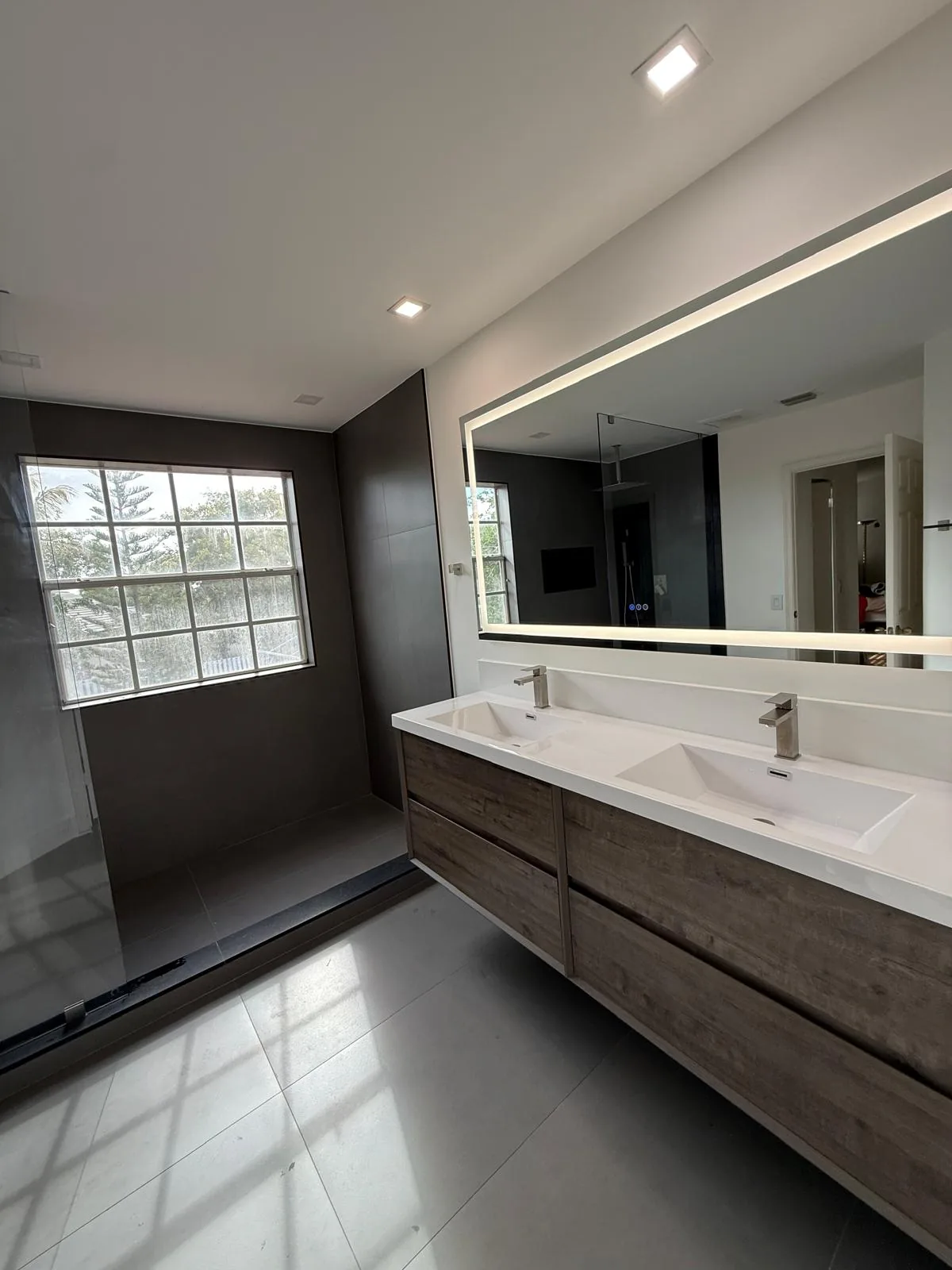 Double vanity with LED backlit mirrors in a South Florida bathroom remodel
