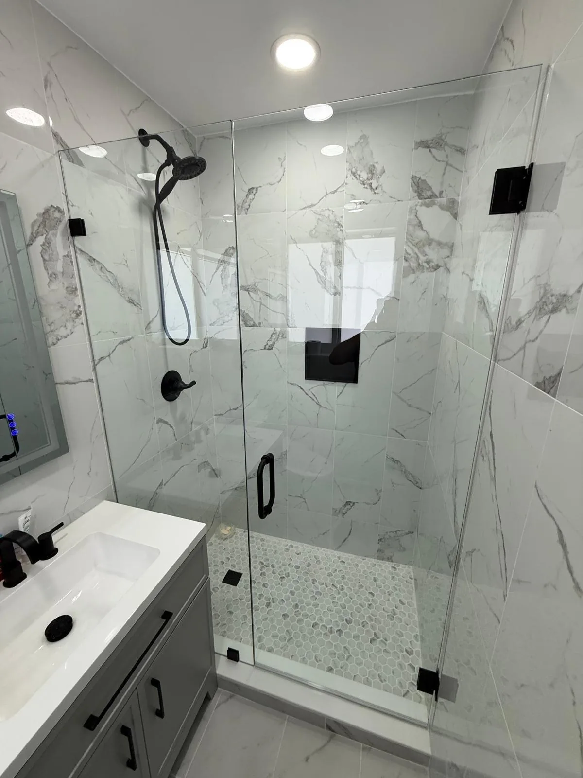 Frameless glass shower with marble tile walls — Boca Raton, FL