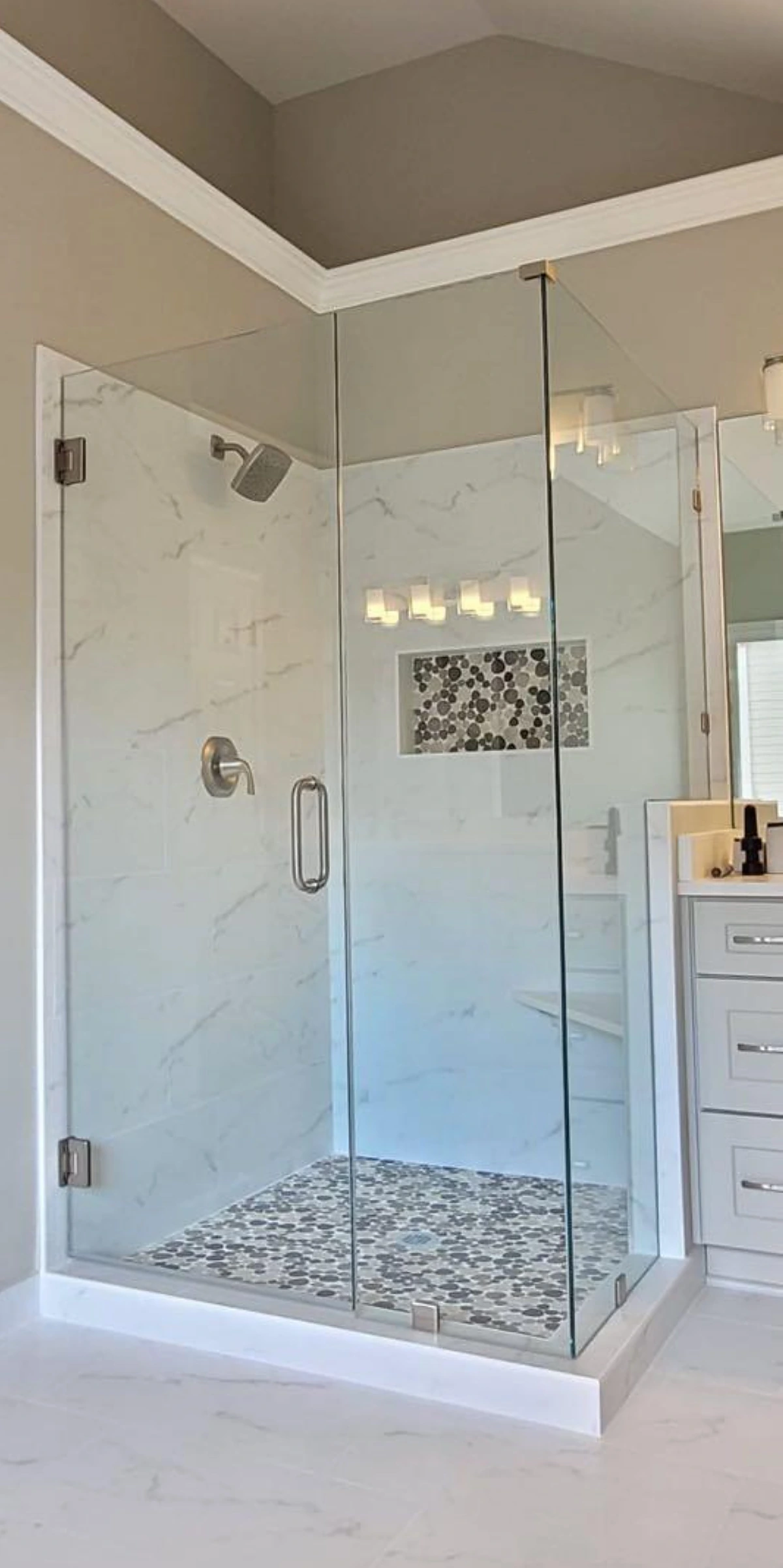 Marble corner shower with built-in bench and mosaic pan