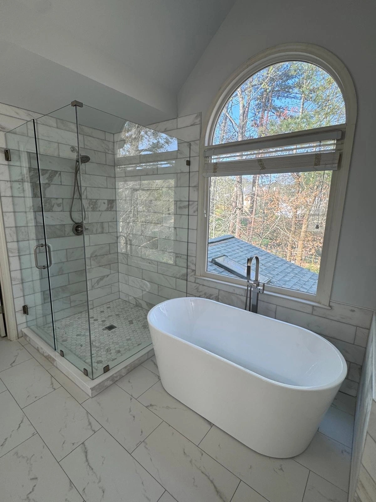 Freestanding tub and glass shower beneath an arched window — Weston, FL
