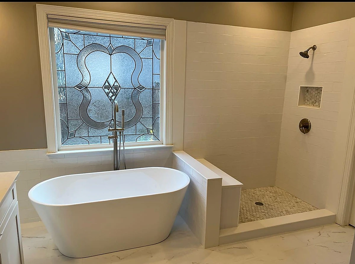 Freestanding tub in an alcove with stained glass window