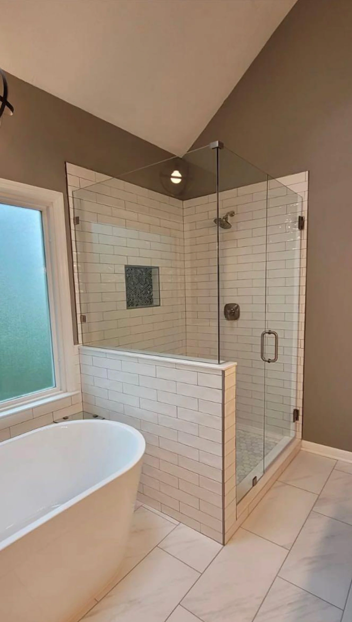 Soaking tub and white subway tile shower enclosure