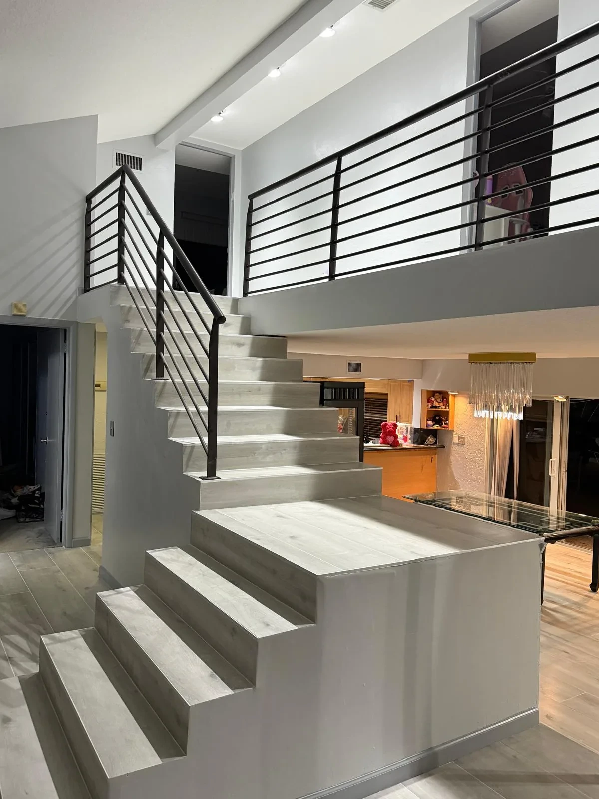Marble-look porcelain staircase treads with black metal railing