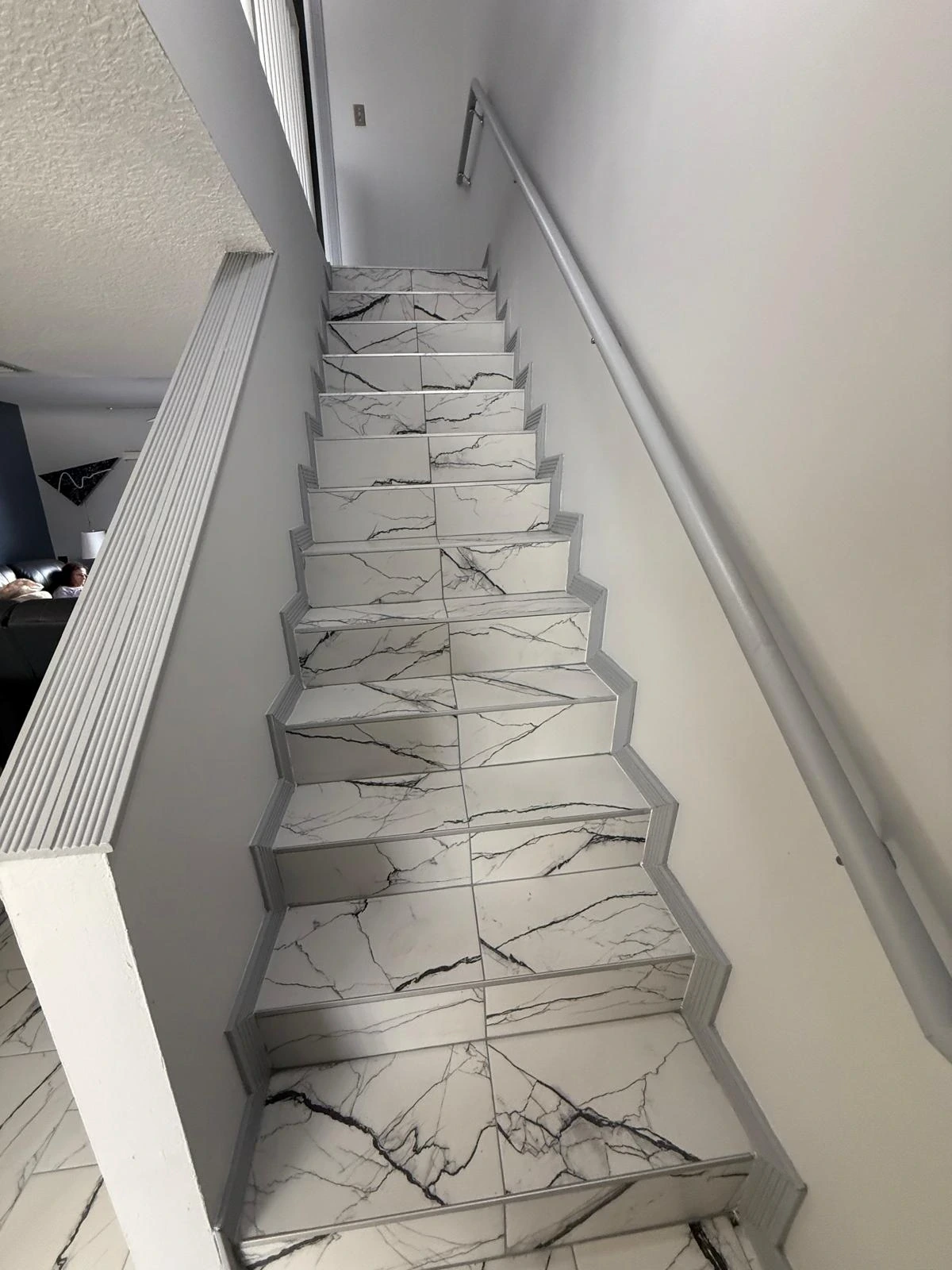 Staircase clad in marble-look porcelain tile