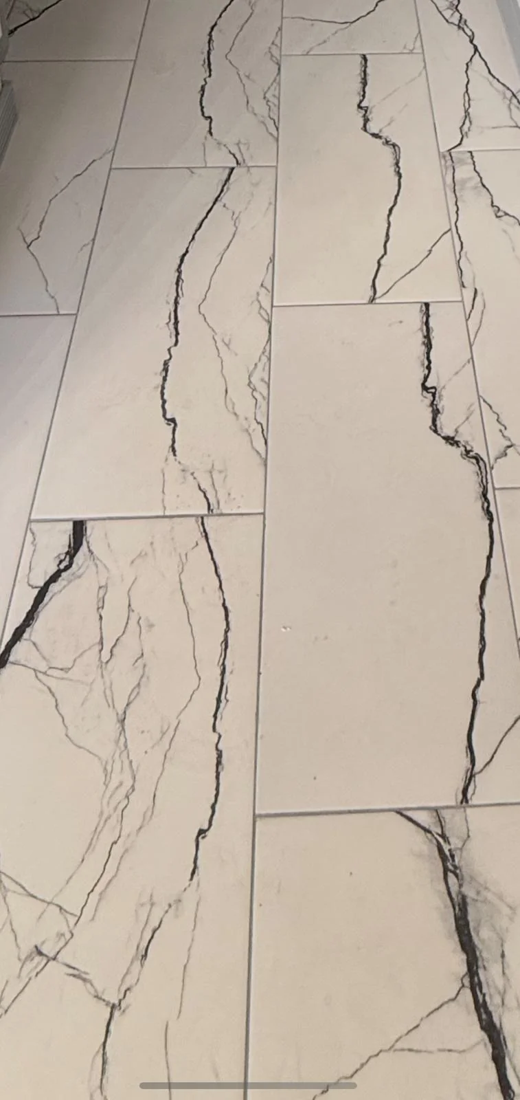Large-format marble-look porcelain tile floor installation close-up by Primer Star Corp in South Florida